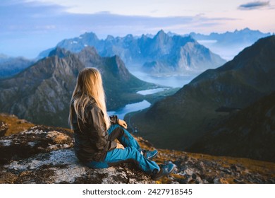 Solo traveler enjoying landscape in Norway Lofoten islands aerial view woman traveling outdoor relaxing on the top of mountain alone healthy lifestyle summer vacations adventure trip - Powered by Shutterstock