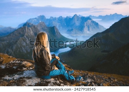 Solo traveler enjoying landscape in Norway Lofoten islands aerial view woman traveling outdoor relaxing on the top of mountain alone healthy lifestyle summer vacations adventure trip