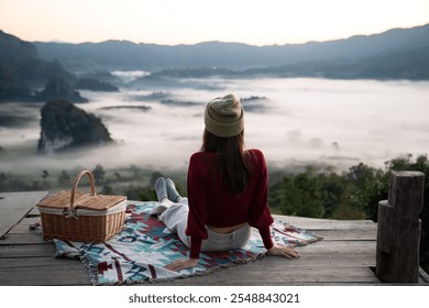 Solo traveler is relaxing on balcony surrounded by green forest and foggy mountain view in the early morning, north of Thailand. Concept of people and healthy natural lifestyle. - Powered by Shutterstock