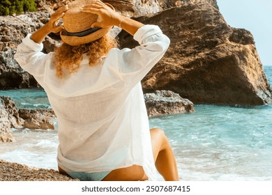 Solo traveler woman stretching her arms and enjoying a peaceful summer day on the beach, gazing at the vast ocean. A perfect scene capturing the essence of solo travel, sunbathing, and relaxation  - Powered by Shutterstock