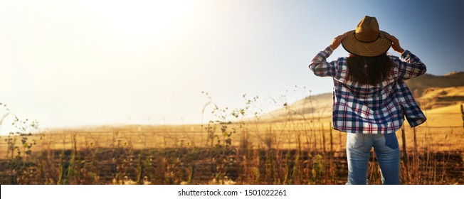 Solo Woman Traveler Wearing Hat From Behind Looking At View Of Rural California Landscape