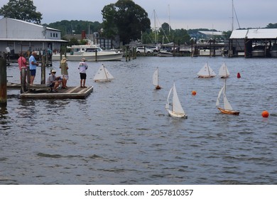 Solomons, Maryland, USA - July 11 2021: Wooden Toy Sailboats Sailing Close To The Shore.