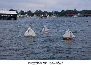 Solomons, Maryland, USA - July 11 2021: Wooden Toy Sailboats Sailing Close To The Shore.