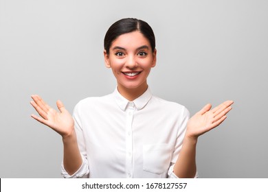 The Solution Was Found. Young Beautiful Woman In White Shirt With Collar Holding Her Palms Up Against Grey Background