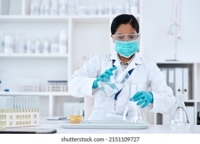 The Solution Lies In Your Hands. Cropped Shot Of An Attractive Young Female Scientist Transferring A Clear Liquid From A Beaker To A Conical Flask While Working In A Laboratory.