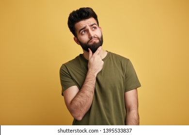 solution of problem. young cute man disposes of a problem, ound. looks up, makes up an idea. isolated yellow background - Shutterstock ID 1395533837