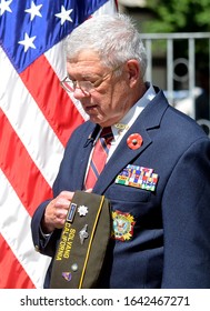 Solvang, California, USA-May 27, 2013:A Military Veteran Bows His Head And Places His Hand Over His Heart During The Playing Of Taps At A Memorial Day Service.