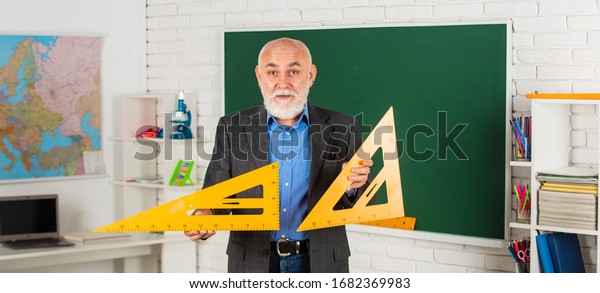 solve some problems. back to school. Math\
science concept with school lesson items. Mathematics at\
chalkboard. senior man teacher use math triangle tool. bearded\
tutor man at blackboard.
