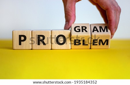 Solving a problem and making program symbol. Businessman turns wooden cubes and changes the word 'problem' to 'program'. Beautiful white background. Business, problem to program concept. Copy space.