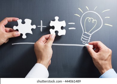 Solving puzzle together. Drawing light bulb on blackboard.
Combining the wisdom for developing new idea.
 - Shutterstock ID 444061489