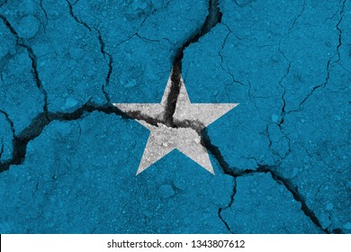 Somalia Flag On The Cracked Earth. National Flag Of Somalia. Earthquake Or Drought Concept