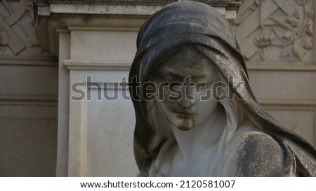 somber stone carved lady at cemetary