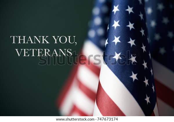 some american flags and the text thank you
veterans against a dark green
background