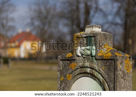 Some anonymous gravestones on the old cemetery in Halmstad, Sweden. Old monuments in a form of a stone object or cross on the grass field. Spring image with no visible people. No names on the graves. 