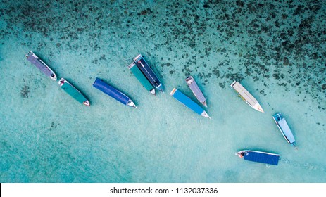 Some boats on a blue ocean parking near an island in Belitung, Indonesia