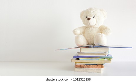 Some Books In A Pile And A Teddy Bear On It. Bookshelf In A Child Bedroom. Empty Copy Space For Editor's Text.