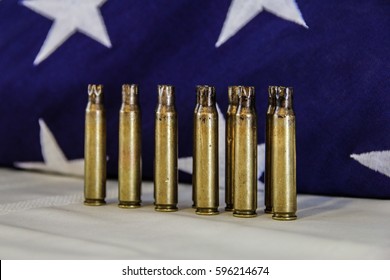 Some Brass From A Veteran's 21 Gun Salute In Front Of An American Flag.