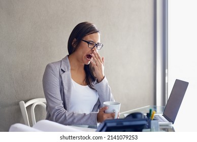 Some Days Seem Longer Than Others. An Attractive Young Businesswoman Yawning While Sitting At Her Desk.