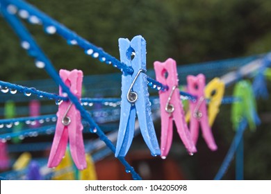 some different coloured clothes pegs on wet washing line