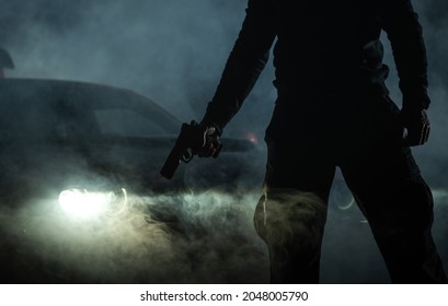 Some Gang Member With Handgun In Front Of His Car During Night Hours. Illegal Night Time Activity Theme.