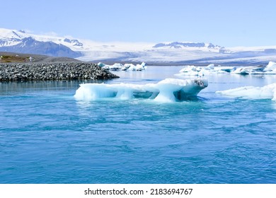 Some glacier icebergs moving towards the sea with snow-capped mountains in the background in Iceland Europe - Shutterstock ID 2183694767