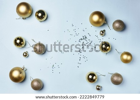 some gold christmas balls and confes on a white surface with scattered confectional objects in the background