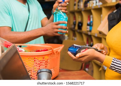 Some Goods Bought From A Supermarket By A Man Being Paid For At The Counter With A Card