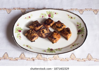 Some Hake Loins In Butter With Garlic And Paprika On A Decorated Antique Plate And A Cloth Tablecloth. Plating Food.