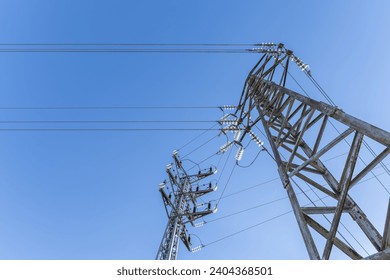 Some high voltage towers with electrical wiring in a low angle