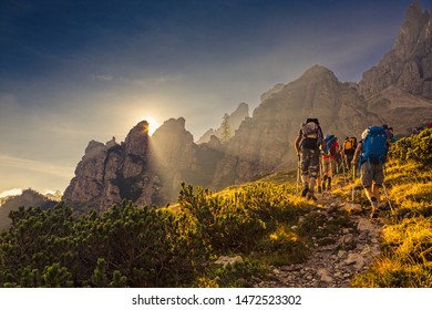 Some hikers go up a mountain path in the early hours of the day