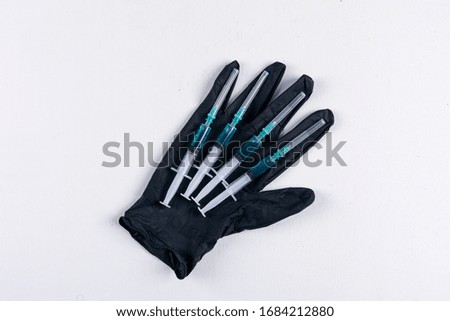 Some medical glove with needles on white background, top view.