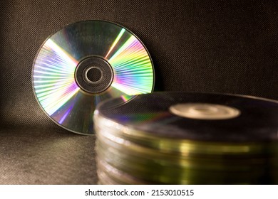Some old Compact Disk, DVDs stacked in a black surface