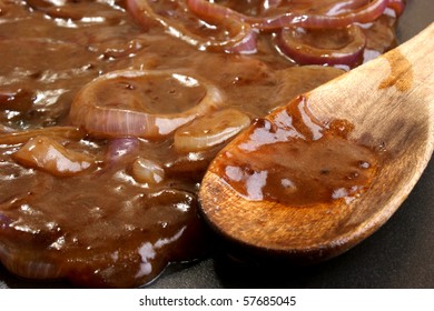 Some Onion Rings With Gravy In A Pan