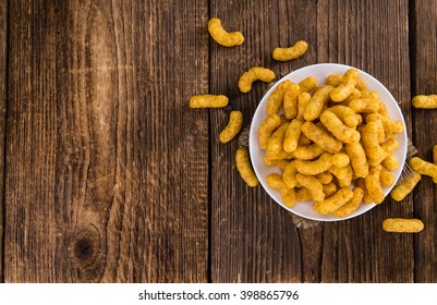 Some Peanut Puffs on wooden background (selective focus; close-up shot)