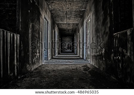 some people sitting in the room at end of scary hallway walkway in abandoned building
