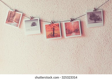 Some Photos Hanging On A Rope, White Wall Background