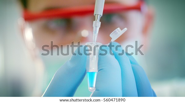 some of the protein test tubes on a sterile\
container with the ice are taken by a hand with sterile gloves for\
analysis of proteins and amino\
acids