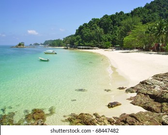 some small boats on a tropical beach in Malaysia - Powered by Shutterstock