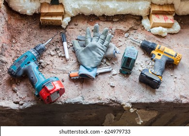 Some Tools - Drill, Screwdriver, Mounting Knife, Mounting Electronic Level And Worker's Gloves Are On The Windowsill During Under Renovation, Remodeling And Construction Of Apartment.