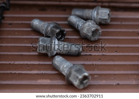 Some used wheel bolts lying around while the brakes are being fixed.