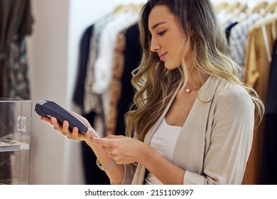 Some Well Deserved Retail Therapy. Shot Of A Woman Using Her Bank Card To Pay For A Purchase In A Store.