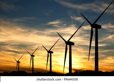 Some wind turbines silhouette in the sunset sky