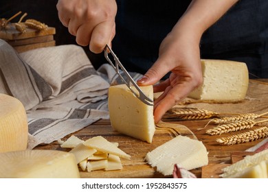 Somebody hands cut a piece of  fresh homemade cheese on a wooden board close up - Powered by Shutterstock