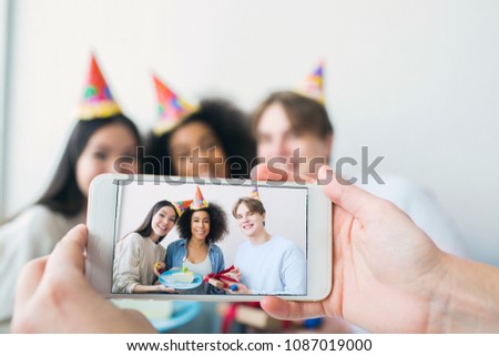Somebody is taking picture on the phone. There are a girl that has birthday and her friends that are gathered together. They are posing and smiling ro camera. Stock foto © 