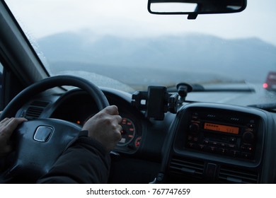 Someone Driving A Car And Holding The Steering Wheel