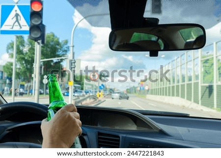 Someone driving and holding a bottle with alchohol. on highway Drunk driving concept