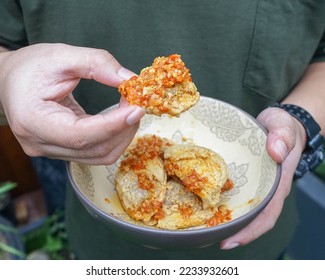 Someone is eat fried tofu with chili. Tahu walik pedas. Indonesian traditional food.  - Shutterstock ID 2233932601