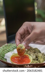 Someone Is Eating Crispy Broccoli, By Dipping The Crispy Broccoli Into The Sauce