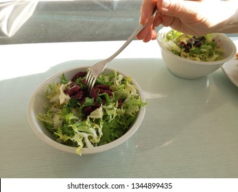 Someone Eating A Homemade Salad On A Table. 