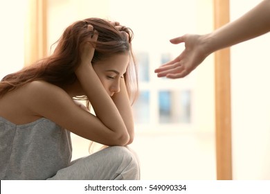 Someone giving hand to depressed woman at home